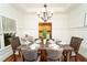 Bright dining room featuring dark wood table set for six and classic wainscoting and bronze chandelier at 550 Quillian Ave, Decatur, GA 30032