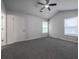 Spacious bedroom with plush carpeting, two windows, and ceiling fan at 5937 Yellowood Ct, Atlanta, GA 30349