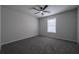 An empty bedroom features gray walls, carpet, a ceiling fan and a window for natural light at 5937 Yellowood Ct, Atlanta, GA 30349