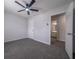 Bedroom view includes a lighted fan, carpet, a door to the bath, and neutral colored walls at 5937 Yellowood Ct, Atlanta, GA 30349