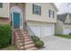 Close-up of the home's entrance, brick steps, teal door, and a two-car garage at 5937 Yellowood Ct, Atlanta, GA 30349