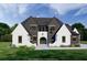 Striking two-story home featuring black and white accents, complemented by a lush green lawn at 7160 Shady Grove Rd, Cumming, GA 30041
