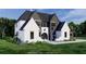 Beautiful home showcasing a blend of white and dark accents on a well-manicured lawn at 7160 Shady Grove Rd, Cumming, GA 30041