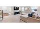 Open-concept living room with plush carpeting, large television, and cozy furniture at 1049 Climbing Rose Way, Mcdonough, GA 30253