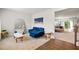 Living room area with a blue sofa, mirror, and access to another living space at 1049 Climbing Rose Way, Mcdonough, GA 30253