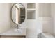 Well-lit bathroom with a floating oval mirror, modern sink, and minimalist toilet, showcasing a clean and contemporary design at 1130 Mclinden Se Ave, Smyrna, GA 30080
