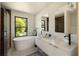 Bright bathroom with soaking tub, double vanity, and modern fixtures at 1130 Mclinden Se Ave, Smyrna, GA 30080