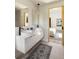 Modern bathroom featuring double sinks, sleek white vanity, and stylish mirrors, seamlessly connecting to a cozy bedroom at 1130 Mclinden Se Ave, Smyrna, GA 30080