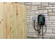 Exterior wall shows an installed Komodo electric car charger on a stone facade next to a wood fence at 1130 Mclinden Se Ave, Smyrna, GA 30080
