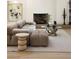 Bright living room featuring a tan sectional sofa, modern art, and a cozy fireplace at 1130 Mclinden Se Ave, Smyrna, GA 30080