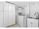Functional laundry room with washer, dryer, sink, and cabinet storage at 1425 Dalewood Ne Dr, Atlanta, GA 30329