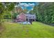 A scenic backyard with a pool, back deck, lush lawn, and treeline at 2230 Ewing Chapel Rd, Dacula, GA 30019