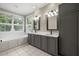 Bright bathroom features a double vanity, large windows, and a soaking tub at 2230 Ewing Chapel Rd, Dacula, GA 30019