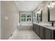 Bright bathroom featuring dual sinks, framed mirrors, and a soaking tub beneath a large window at 2230 Ewing Chapel Rd, Dacula, GA 30019