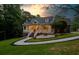 Inviting two-story home with landscaped yard, attractive front porch, and lovely lawn at sunset at 2230 Ewing Chapel Rd, Dacula, GA 30019