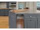 A kitchen island features a grey countertop, cabinets, and a built-in wine cooler at 2230 Ewing Chapel Rd, Dacula, GA 30019
