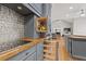 A well-equipped kitchen boasts gray cabinets with wood countertops, stainless steel appliances, and tiled backsplash at 2230 Ewing Chapel Rd, Dacula, GA 30019