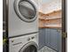 Cozy laundry area features grey cabinets, a stacking washer and dryer, and tiled flooring at 2230 Ewing Chapel Rd, Dacula, GA 30019