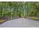 Large backyard featuring a grey wooden deck and a wooded treeline for privacy at 315 Glengarry Chase, Covington, GA 30014