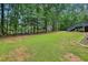 The backyard has green grass surrounded by mature trees; a deck overlooks it at 315 Glengarry Chase, Covington, GA 30014