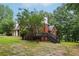 Expansive backyard view of brick home with deck and stairs overlooking mature trees at 315 Glengarry Chase, Covington, GA 30014