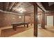 Unique basement with exposed brick, ping pong table, and wooden floors, perfect for entertainment at 315 Glengarry Chase, Covington, GA 30014
