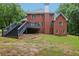 Beautiful backyard featuring a two-story brick house, a large deck, and a well-manicured lawn at 315 Glengarry Chase, Covington, GA 30014