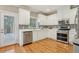 Modern kitchen with stainless steel appliances, white cabinets, and hardwood floors at 315 Glengarry Chase, Covington, GA 30014