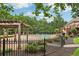 Community pool with wooden pergola and iron fence, surrounded by mature trees at 315 Glengarry Chase, Covington, GA 30014