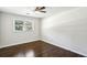 Well-lit bedroom with hardwood floors, ceiling fan, and large window letting in natural light at 3301 Irish Ln, Decatur, GA 30032