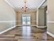 Formal dining room boasts elegant chandelier, wood-look flooring and decorative trim at 4601 Ethel Springs Sw Trl, Mableton, GA 30126
