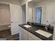Double vanity bathroom with granite counter tops and a view into other rooms at 1672 Fuma Leaf Way, Mcdonough, GA 30252