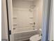 Bathroom with white tub, toilet, and open door at 1672 Fuma Leaf Way, Mcdonough, GA 30252