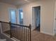 Hallway with railing, carpet, and doors leading to bedrooms at 1672 Fuma Leaf Way, Mcdonough, GA 30252