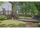 Spacious backyard with a wooden deck, lush green grass, mature trees, and privacy fence at 2411 Second Ave, Decatur, GA 30032