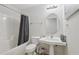 Clean, bright bathroom featuring a pedestal sink, oval mirror, and shower-tub combination with a gray curtain at 2825 Ellenwood Village Way, Ellenwood, GA 30294