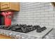 Close-up of cooktop with white backsplash and granite counters, with red cooking utensils for contrast at 2825 Ellenwood Village Way, Ellenwood, GA 30294