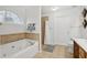Spa-like bathroom with jetted tub, tiled shower, and a bright window for natural light at 2825 Ellenwood Village Way, Ellenwood, GA 30294