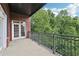 Open-air balcony with iron railings and French doors offers views of lush trees at 3280 Stillhouse Se Ln # 212, Atlanta, GA 30339