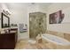 Bathroom featuring a standalone tub, glass shower, vanity with granite countertop, and tile flooring at 3280 Stillhouse Se Ln # 212, Atlanta, GA 30339