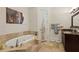Bathroom with a standalone tub, stone tile, framed art, and granite countertop at 3280 Stillhouse Se Ln # 212, Atlanta, GA 30339