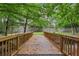Charming wooden bridge over a serene creek, surrounded by lush greenery and mature trees at 3280 Stillhouse Se Ln # 212, Atlanta, GA 30339