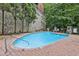 Inviting outdoor pool area surrounded by lush landscaping and a stone wall at 3280 Stillhouse Se Ln # 212, Atlanta, GA 30339