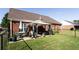 Backyard features a covered patio with an outdoor dining set, lush grass and fenced perimeter at 381 Crossroads Dr, Social Circle, GA 30025