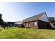 Expansive backyard featuring a covered patio, well-maintained lawn, and fenced perimeter at 381 Crossroads Dr, Social Circle, GA 30025