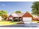 Charming single-story brick home with a well-manicured lawn and attached two-car garage at 381 Crossroads Dr, Social Circle, GA 30025