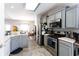 Modern kitchen featuring stainless steel appliances, light cabinetry, and an adjacent dining area for easy entertaining at 381 Crossroads Dr, Social Circle, GA 30025