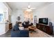 Well lit living room boasts wood floors, a ceiling fan, neutral color scheme, and open access to dining area at 381 Crossroads Dr, Social Circle, GA 30025
