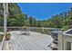 View of an outdoor dining set and grill on an elevated wooden deck at 3909 Laurens Ln, Snellville, GA 30039