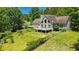 Charming home featuring a large deck, yard and mature trees on a sunny day at 3909 Laurens Ln, Snellville, GA 30039